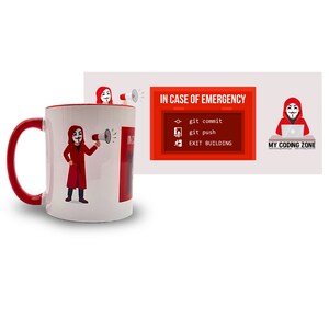 Könnte beinhalten: Eine weiße Keramiktasse mit rotem Rand und Henkel. Die Tasse zeigt ein Cartoon-Bild einer Person, die einen roten Kapuzenumhang und eine Guy-Fawkes-Maske trägt und ein Megaphon hält. Der Text "IN CASE OF EMERGENCY" ist auf die Tasse gedruckt. Der Text "git commit", "git push" und "EXIT BUILDING" ist unter dem Text "IN CASE OF EMERGENCY" aufgelistet.