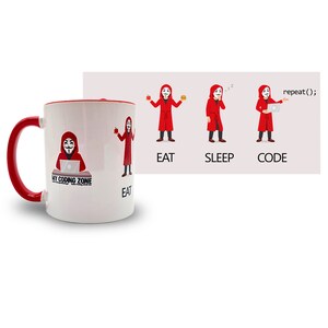 Könnte beinhalten: Eine weiße Keramiktasse mit rotem Rand und Henkel. Die Tasse zeigt ein Cartoon-Bild einer Person, die einen roten Umhang mit Kapuze und eine Guy-Fawkes-Maske trägt. Der Text "My Coding Zone" ist auf die Tasse gedruckt. Die Tasse befindet sich neben einem weißen rechteckigen Bild mit einem Cartoon-Bild einer Person, die einen roten Umhang mit Kapuze und eine Guy-Fawkes-Maske trägt. Die Person ist in vier verschiedenen Posen dargestellt: beim Apfelessen, beim Schlafen, beim Programmieren auf einem Laptop und beim Halten eines Hamburgers. Der Text "EAT", "SLEEP", "CODE" und "repeat();" ist unter den Bildern gedruckt.