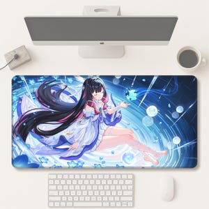 Può includere: Un grande tappetino per mouse rettangolare con un'illustrazione in stile anime di una donna con lunghi capelli neri e un abito bianco e blu fluente. Lo sfondo presenta un design blu e bianco simile all'acqua con bolle. Sono visibili anche una tastiera, un mouse e un monitor del computer.