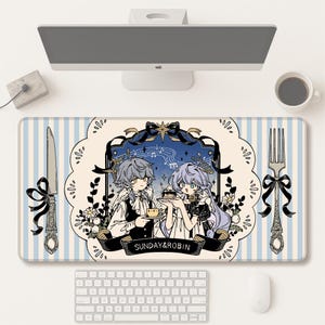 May include: A rectangular desk mat with a light blue and white striped design. The mat features an illustration of two anime-style characters holding a cake. A knife and fork with black bows are on either side. The text "SUNDAY&ROBIN" is on the mat.