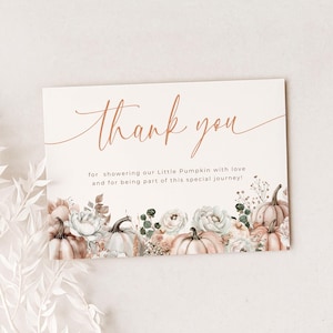 Peut inclure: Carte de remerciement avec un motif de citrouille florale. La carte présente les mots "thank you" dans une police script cuivrée. Le bas de la carte présente des citrouilles, des roses et de la verdure à l'aquarelle. Le texte se lit comme suit : "pour avoir comblé notre Little Pumpkin d'amour et pour avoir fait partie de ce voyage spécial !"