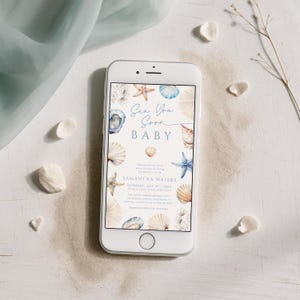 May include: A white smartphone displays a baby shower invitation with a sea-themed design. The invitation features seashells, starfish, and the text "Sea You Soon BABY." The invitation includes the name "Samantha Waters" and event details.