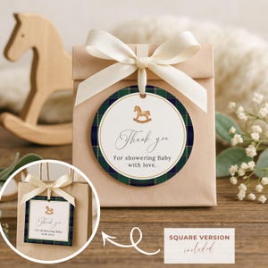 Peut inclure: Un sac cadeau avec un nœud crème et une étiquette ronde. L'étiquette a une bordure à carreaux verts et marine et le texte "Thank you for showering Baby with love." Un cheval à bascule en bois est visible.