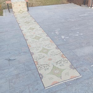 Może przedstawiać: Rustykalny drewniany szyld z napisem "Welcome to our home" w białych literach. Szyld ma postarzaną powierzchnię i prosty, zapraszający design.