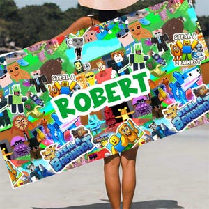 May include: A rectangular beach towel featuring a colorful collage of cartoon characters and the name "ROBERT" in large green letters. The towel has a vibrant design with various figures and the text "STEAL A BRAINROT".