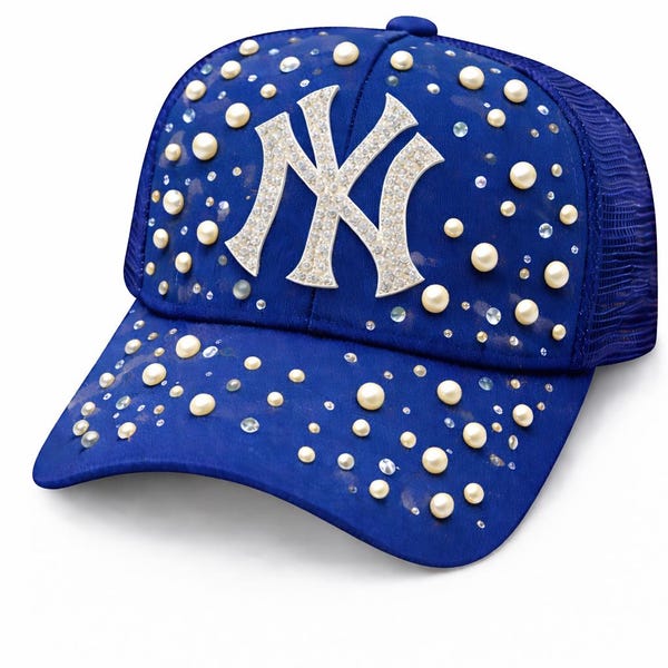 May include: Royal blue baseball cap with a mesh back, adorned with faux pearls and rhinestones. The front features a silver glitter "NY" logo. A stylish accessory for sports fans.