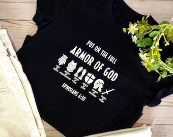 May include: Black t-shirt with white text that reads "Put on the full Armor of God" and a graphic of the armor of God with the scripture reference "Ephesians 6:10".