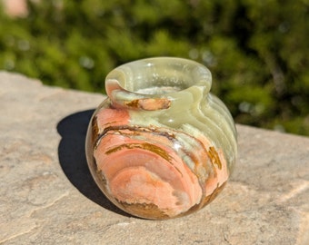 Può includere: Un piccolo vaso rotondo in onice verde, marrone e rosa con una finitura liscia e lucida.
