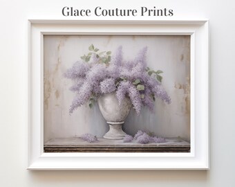 May include: A framed print of a still life featuring a white vase filled with purple lilac flowers. The vase is on a wooden table against a textured white background. The print is titled "Glace Couture Prints".