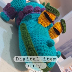 Op de afbeelding: Haak amigurumi patroon voor een turquoise blauwe draak met paarse, groene en gele details. Het patroon is een digitale download in PDF-formaat. Alleen digitaal item.