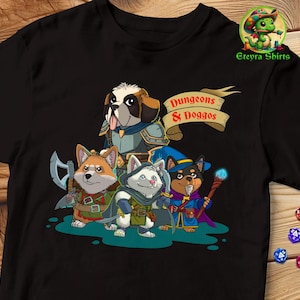 Puede incluir: Camiseta negra con un gráfico de cuatro perros de dibujos animados vestidos como personajes de Dungeons & Dragons. El texto "Dungeons & Doggos" está en la camiseta.