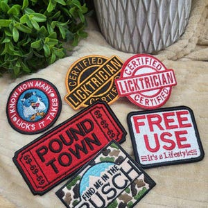 May include: Six embroidered patches with various designs and text. The patches include "Certified Licktrician", "Pound Town", "Find Me in the Busch", "Free Use - It's a Lifestyle", and two other patches with text that is too small to read.