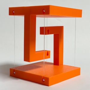May include: An orange geometric sculpture with a three-dimensional design. The sculpture features a base, a top, and a central shape, all connected by clear, thin supports. The bright orange color and the unique shape make it a striking piece of art.
