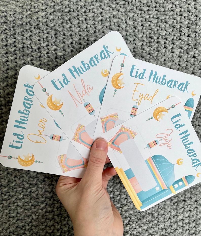 K&ouml;nnte beinhalten: Vier bunte Karten mit dem Text "Eid Mubarak" und verschiedenen Namen auf jeder Karte. Die Karten zeigen einen Halbmond, eine Moschee und eine Laterne.