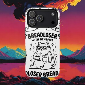 May include: A white smartphone case featuring a black line art illustration of a cat wearing sunglasses, holding a martini glass, and carrying a baguette in its pocket. The text reads BREADLOSER WITH BENEFITS, surrounded by small star icons.