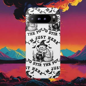 Puede incluir: Funda de teléfono blanca con un gato de dibujos animados con sombrero de bruja revolviendo un caldero. El texto "I'm just here to stir the pot" se muestra alrededor del gato. La funda tiene un recorte negro para la cámara.