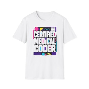 以下が含まれることがあります： 「CERTIFIED MEDICAL CODER」という白い太字のテキストが中央に配置された、白い半袖Tシャツ。デザインは、ピンクの円、黄色の三角形、紫の長方形など、カラフルな幾何学模様で囲まれています。