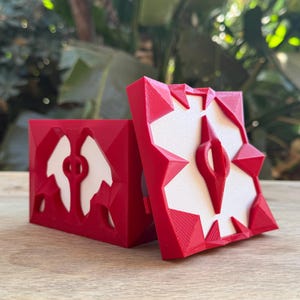 May include: A red 3D printed box with a white design on the lid. The box is open and the lid is resting on the side. The box has a geometric design.