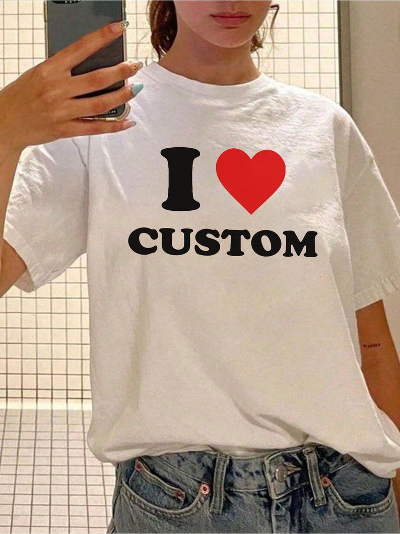 Op de afbeelding: Wit T-shirt met een zwarte afbeelding die "I heart CUSTOM" zegt.
