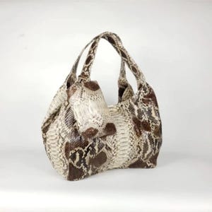 Model wearing the Genuine White Brown Python Leather Shoulder Bag, walking down the street with a confident and chic look. The bag adds a sophisticated touch to any outfit, perfect for both day and evening wear.