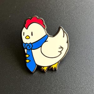 May include: A white chicken with a red comb and a blue tie. The chicken is wearing a blue tie with yellow accents. The chicken is looking to the left.