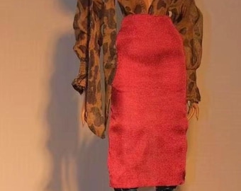 May include: A red pencil skirt paired with a brown leopard print blouse with long, voluminous sleeves. The outfit is completed with green boots. The clothing is displayed on a mannequin.