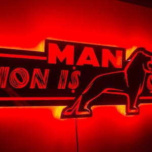 Op de afbeelding: Een rood neonbord met het MAN-logo en de tekst "Lion is only one".