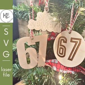 May include: Wooden Christmas tree decorations featuring the numbers "67" and the words "Six Seven" are displayed on a Christmas tree. The ornaments are made of light-coloured wood and are suspended by red and white twine. The tree is decorated with red and green plaid ribbon.