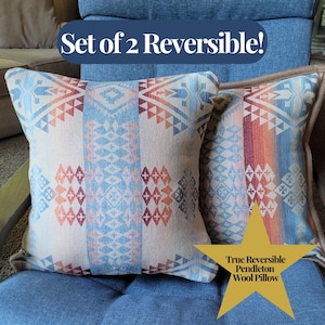 May include: Two reversible Pendleton wool pillows with geometric patterns in shades of blue, orange, and beige. The pillows are displayed on a blue chair. Text on the image reads "Set of 2 Reversible!" and "True Reversible Pendleton Wool Pillow."