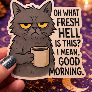 May include: A sticker featuring a grumpy gray cat with yellow eyes holding a coffee cup. The sticker has the text "OH WHAT FRESH HELL IS THIS? I MEAN, GOOD MORNING." in black font.