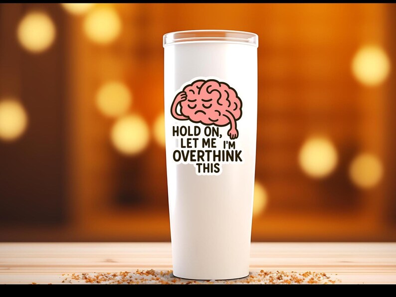 May include: A white tumbler with a humorous sticker featuring a pink brain with a hand on its head. The text on the sticker reads "Hold on, let me I'm overthink this."