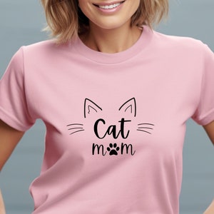 May include: A pink t-shirt with a black cat graphic and the text "Cat mom" with a paw print.