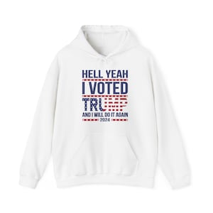 May include: White hooded sweatshirt with the text "Hell Yeah I Voted Trump and I will do it again 2024" printed on the front. The text is in blue and red with a small American flag graphic.