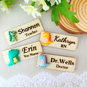May include: Four wooden name tags with dinosaur figurines attached. The name tags read "Shannon Teacher", "Erin Vet Nurse", "Kathryn RN", and "Dr. Wells Doctor".