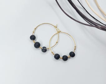 May include: Gold hoop earrings with black and white marbled beads.
