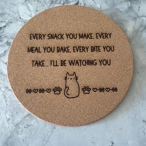 May include: Round cork coaster with a black cat illustration and the text "EVERY SNACK YOU MAKE, EVERY MEAL YOU BAKE, EVERY BITE YOU TAKE... I'LL BE WATCHING YOU".