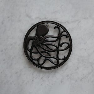 GASARÉ, Cast Iron Trivet for Hot Dishes, Vintage Trivet, Octopus Design, Rubber Feet Caps, Ring Hanger, 8 Inches, Brown