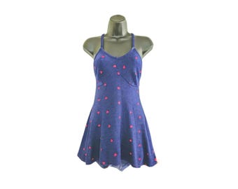 May include: A blue dress with a halter top and a flared skirt, displayed on a mannequin. The dress is adorned with small, evenly spaced pink heart-shaped patterns. The fabric appears to be a soft, textured material.