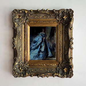 May include: An oil painting of a woman in a blue dress, framed in a gold ornate frame.
