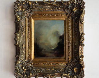 May include: A framed oil painting depicting a seascape with a hazy, atmospheric effect. The painting is set in a gold-colored ornate frame with intricate carvings.