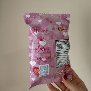 May include: A pink Lays potato chip bag with a heart pattern and the words "Gracias por celebrar conmigo!" in script. The bag also has a QR code and a "Birthday Girl" nutrition facts label.