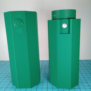 Könnte beinhalten: Zwei grüne Plastikbehälter mit sechseckiger Form. Die Behälter sind leer und haben eine glatte Oberfläche.