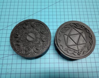 May include: Two black 3D printed dice trays. One tray features a circular design with a raised center. The other tray features a 20-sided die design.