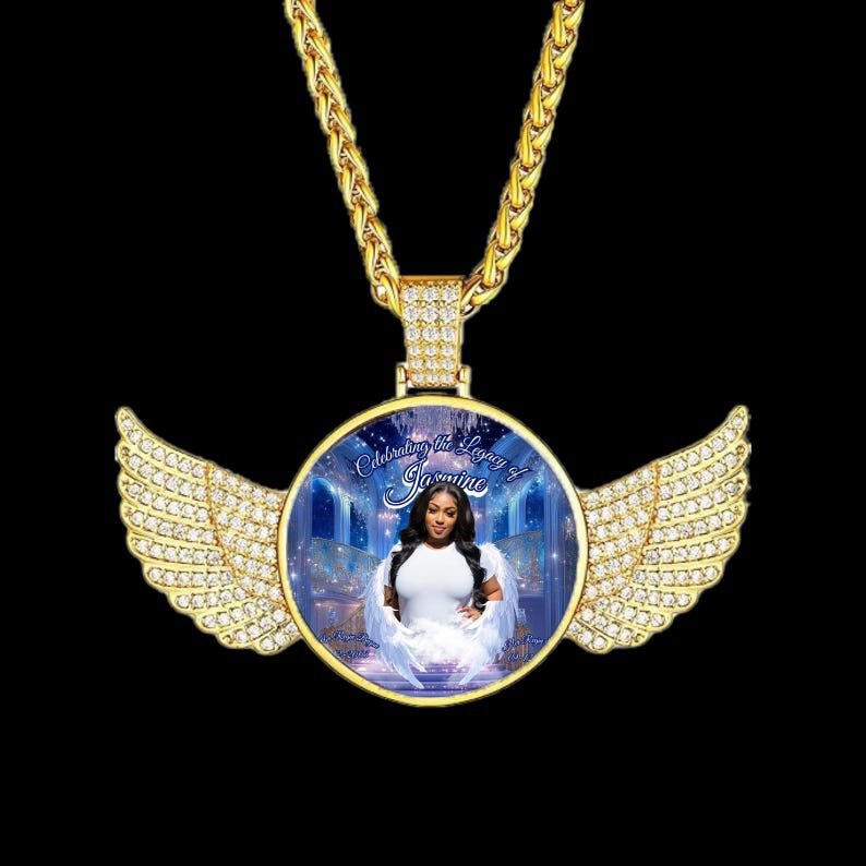 Puede incluir: Collar con colgante dorado con un dije redondo y alas con incrustaciones de diamantes. El dije muestra una foto de una mujer con un vestido blanco y el texto "Celebrating the Legacy of Jasmine". La cadena es gruesa y texturizada.