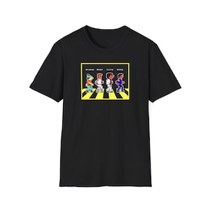 May include: Black t-shirt featuring a graphic of four pixelated figures walking across a yellow and black zebra crossing. The text "Graham Roger Larry Sonny" is above the figures.