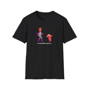 May include: Black t-shirt featuring a pixelated image of two characters from a video game. The text '> say the word_' is printed below the image.