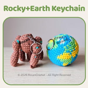 Puede incluir: Dos llaveros de ganchillo: una figura marrón con forma de oso y un globo azul, verde y amarillo. Los llaveros están conectados a llaveros plateados. El texto "Rocky+Earth Keychain" está arriba.