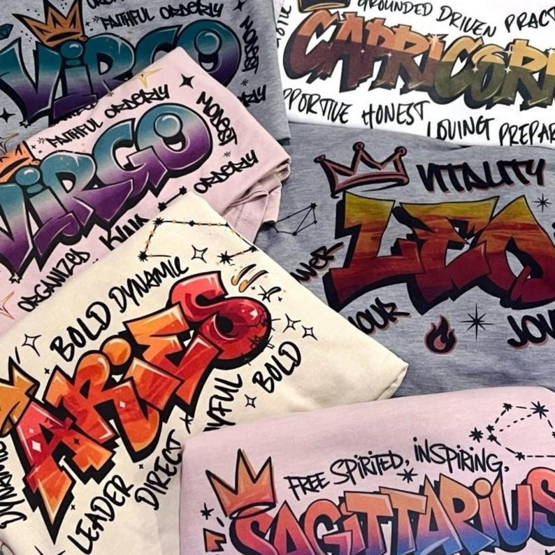 a pile of t - shirts with various designs on them