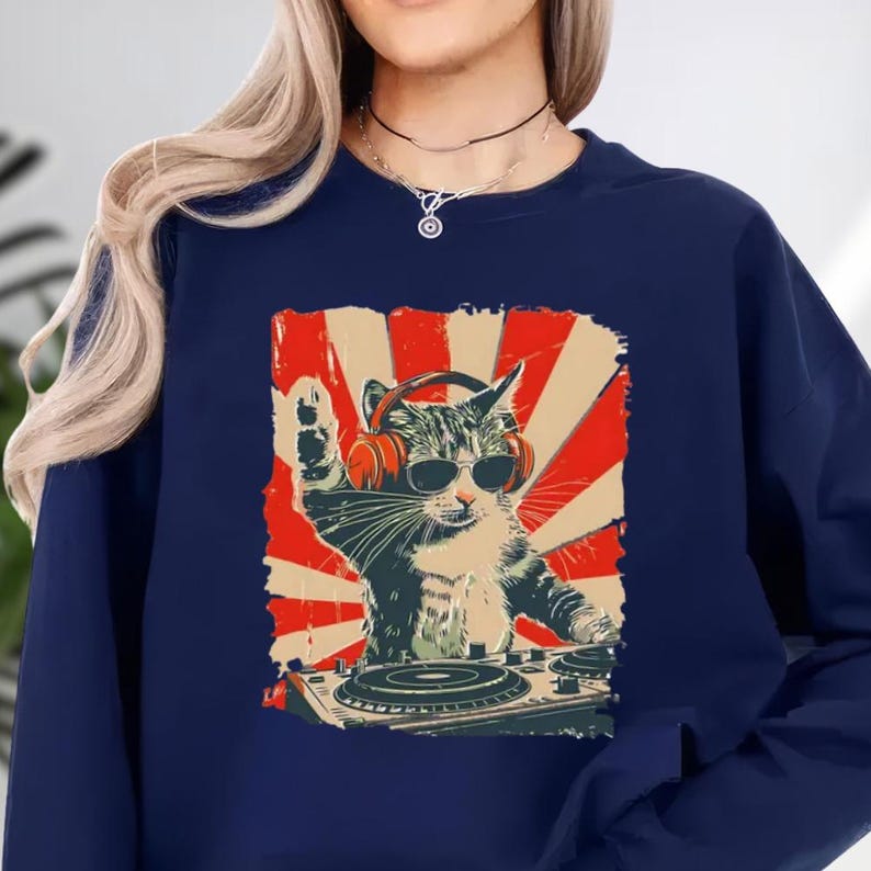 A woman wearing a navy blue sweatshirt with a graphic design depicting a cat wearing sunglasses and a DJ turntable.