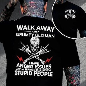 May include: Black t-shirt with a skull graphic and the text "WALK AWAY I AM A GRUMPY OLD MAN". Below the text is a graphic of a skull with crossed bones and the text "I HAVE ANGER ISSUES AND A SERIOUS DISLIKE FOR STUPID PEOPLE". A smaller image shows "GENERATION X 19 66".